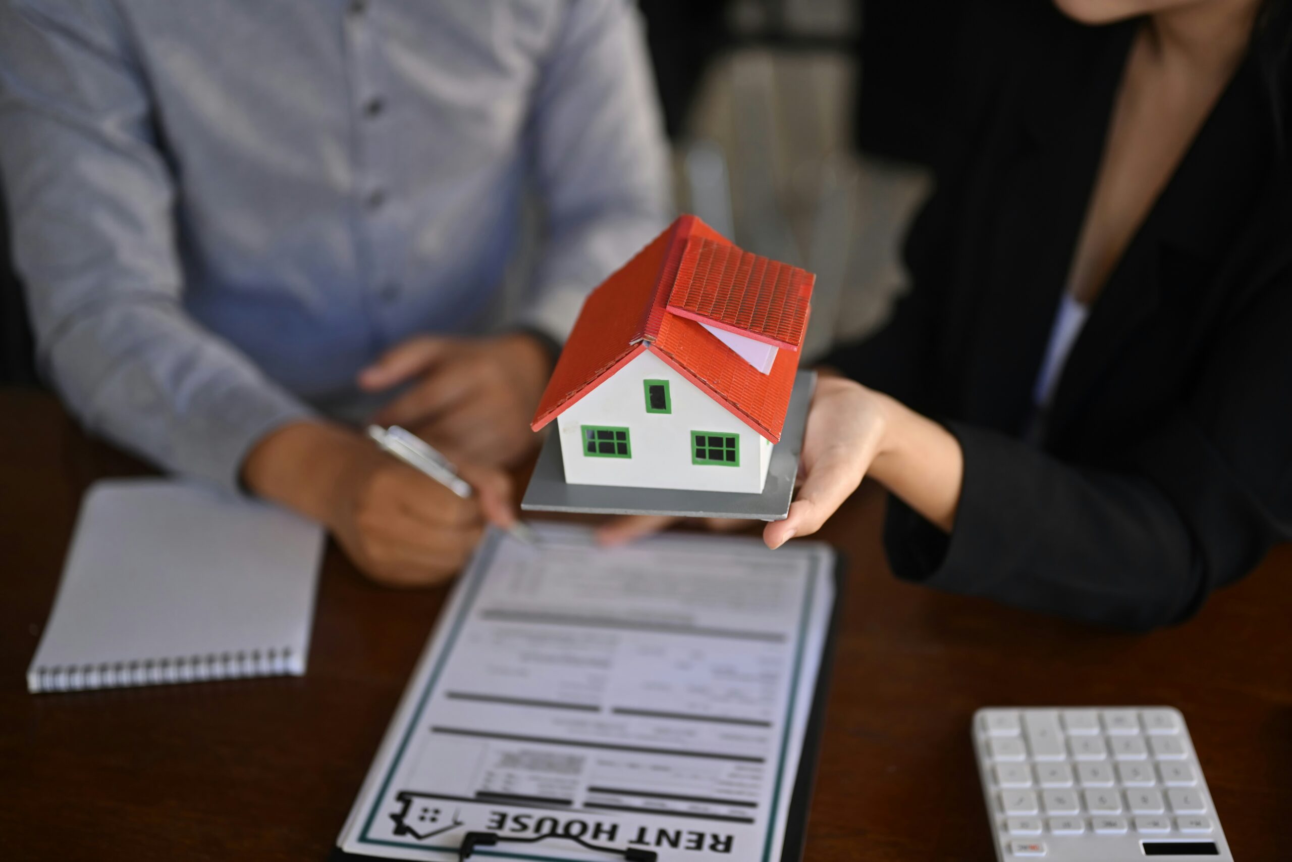 two hands holding a model home